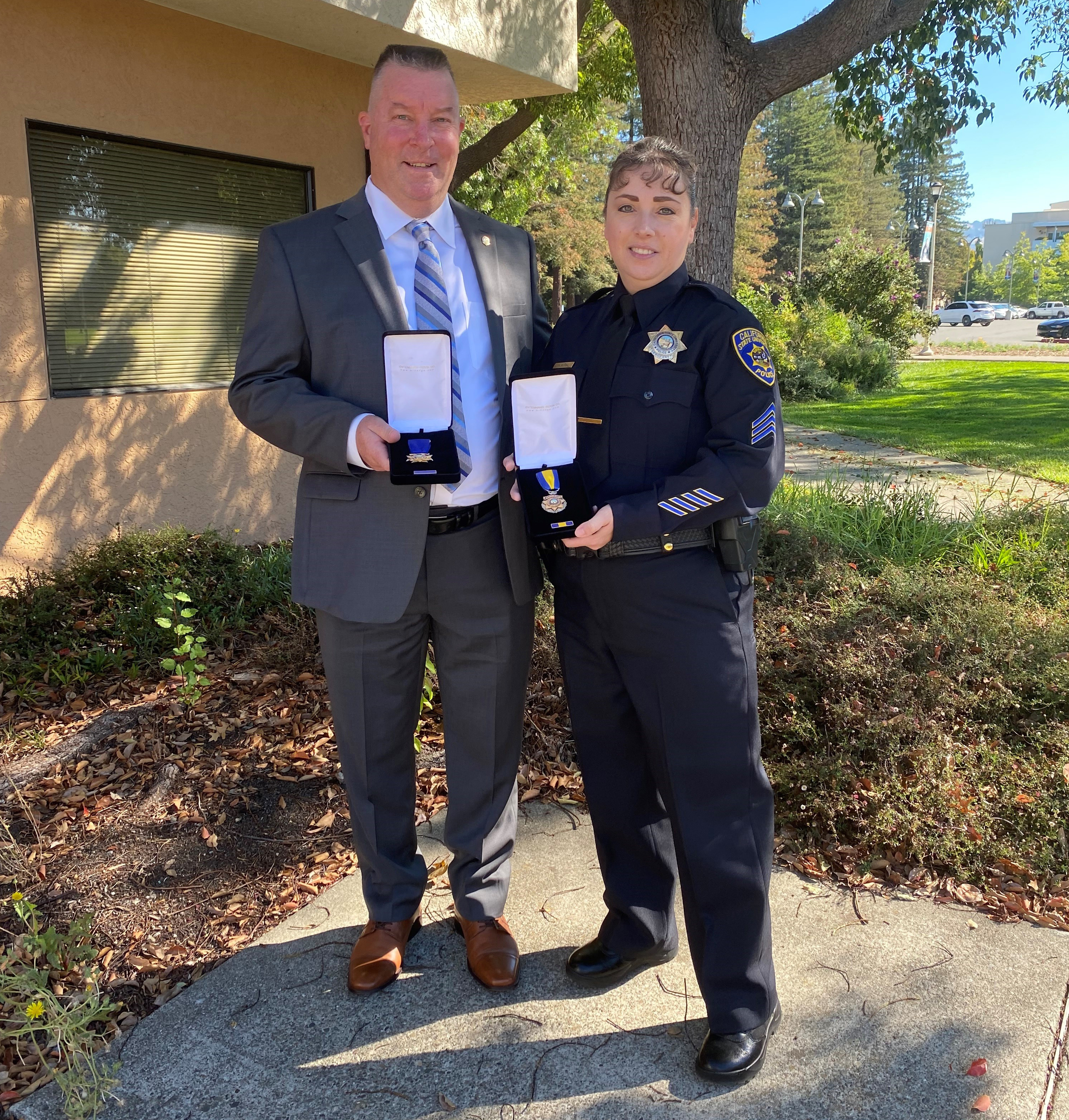 two police officers holding awards