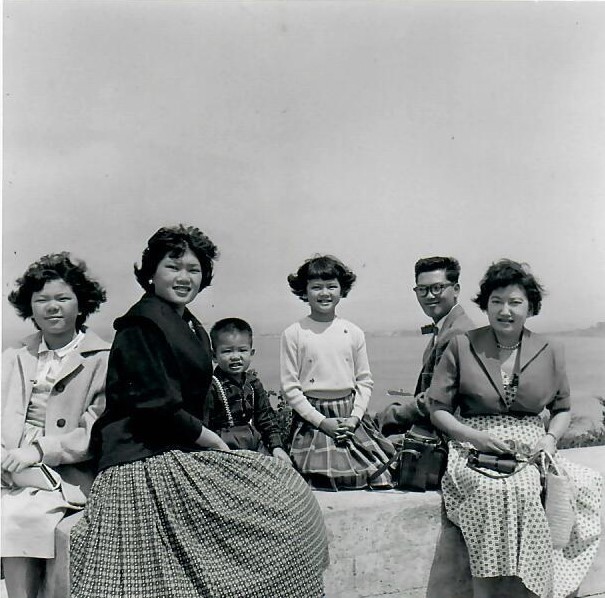 a black and white photo of a mother and her five small children