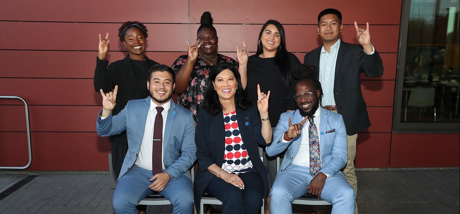 a group of smiling college students with an administrator