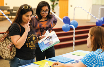 photo of student and parent getting materials at campus