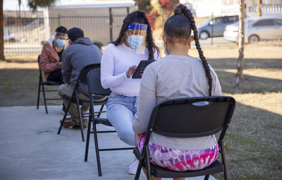 : SDSU community health workers collect demographic information from community members while waiting for COVID-19 rapid testing results.