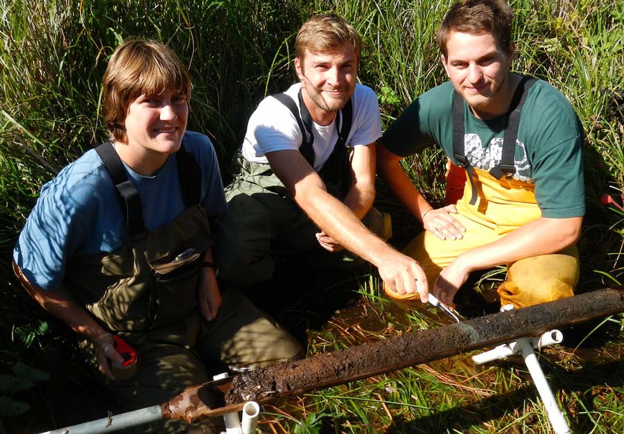 Vermeer, Loofbourrow and Crawford examine a core from the marsh in 2017, pointing to a gray sand layer deposited by the 1700 tsu