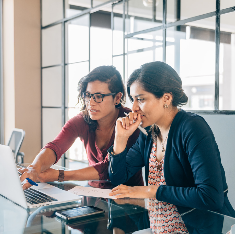 Two women working on a laptop.
