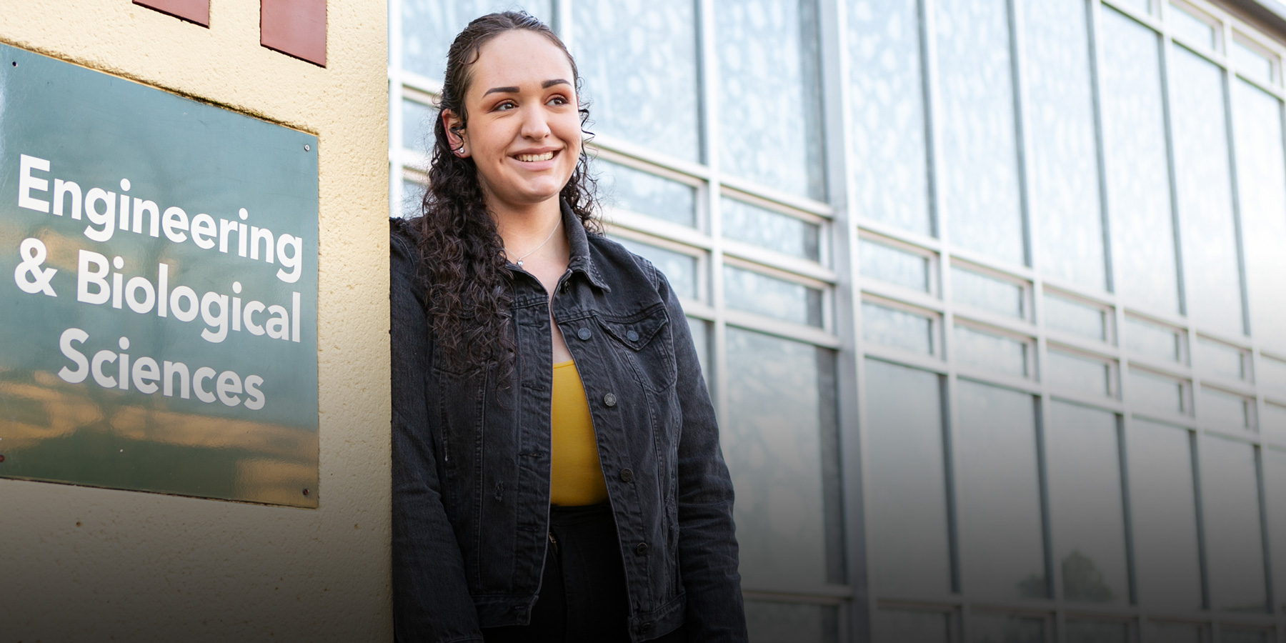Maria stands at the Engineering & Biological Sciences building at HSU.